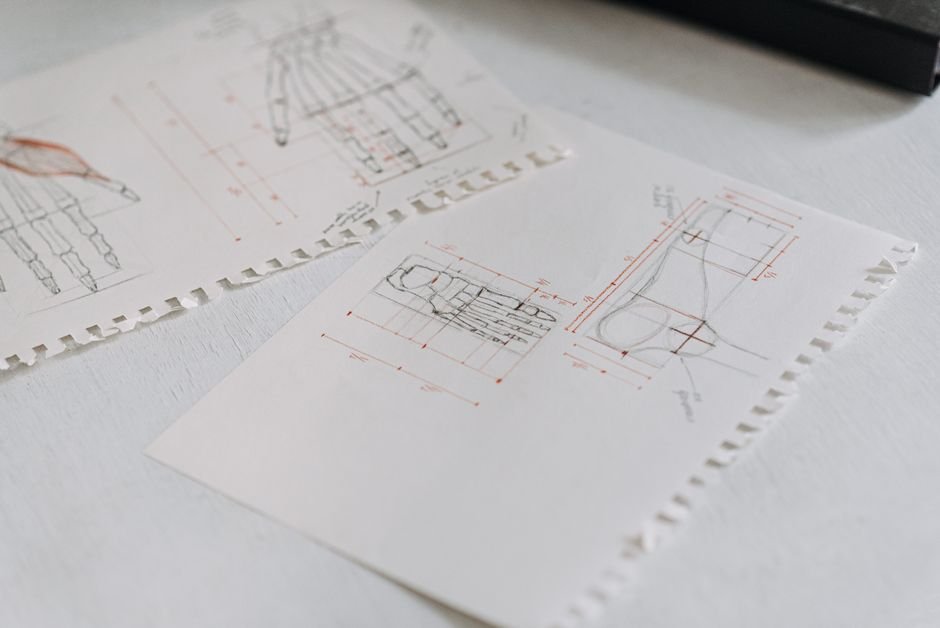 Close-up of detailed technical drawings on neatly arranged white paper sheets, highlighting design concepts.